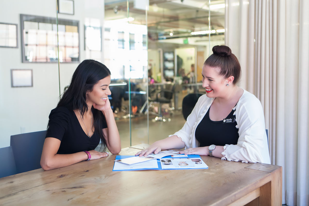 Image of a student speaking with an admissions representative  at aveda institute portland