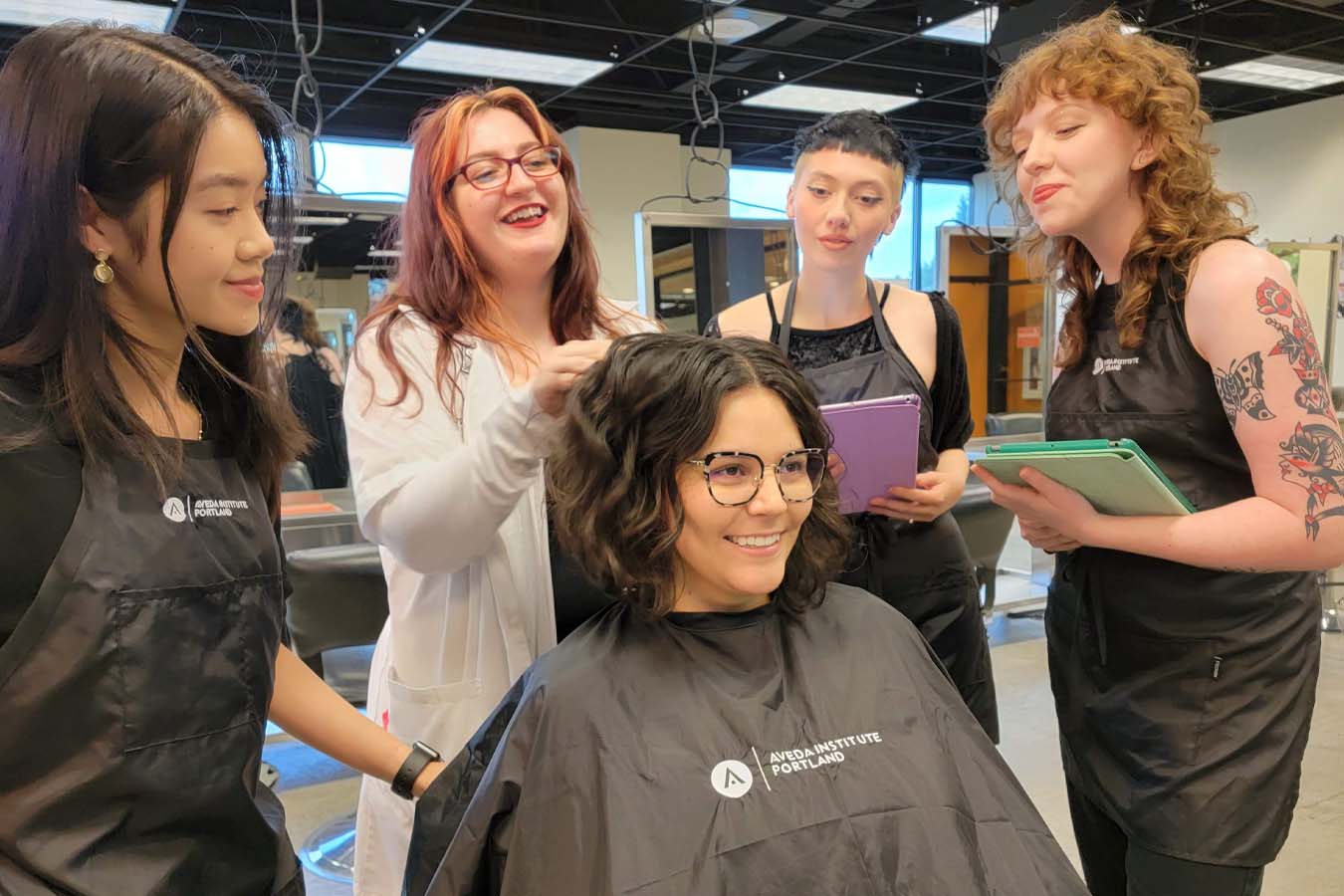 image of students learning hands on behind the stylists chair
