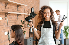 A hair stylist in salon smiling