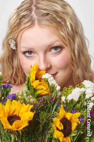 Image of a student photoshoot of a student model with long blonde hair holding a bouquet of sunflowers and white flowers