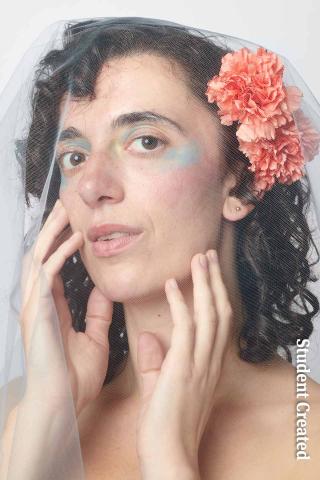 Image of a student photoshoot with a model with short curly hair wearing a white veil with peach colored flowers