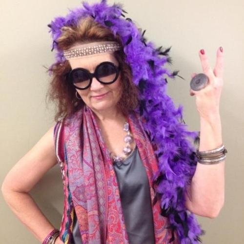 Aveda Institute Portland Instructor dressed up with big sunglasses and a purple feather boa.